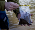Man holding a sample of dirt in a bag